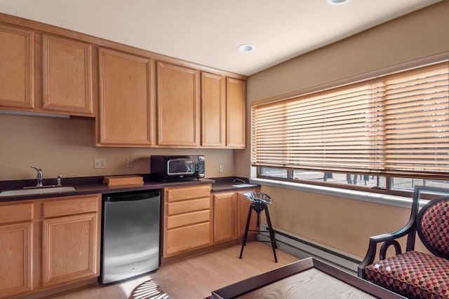 kitchen featuring dishwashing machine, sink, light hardwood / wood-style floors, and a baseboard heating unit