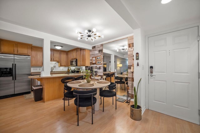 dining area featuring an inviting chandelier and light hardwood / wood-style floors