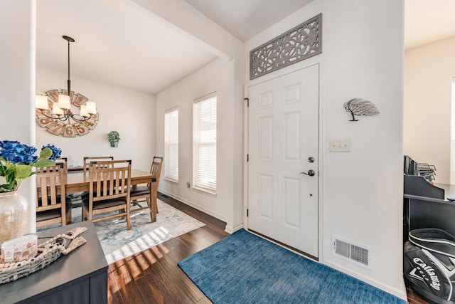 foyer entrance featuring dark wood-type flooring and a notable chandelier