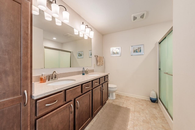 bathroom featuring toilet, a shower with door, and vanity