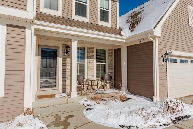 snow covered property entrance featuring covered porch