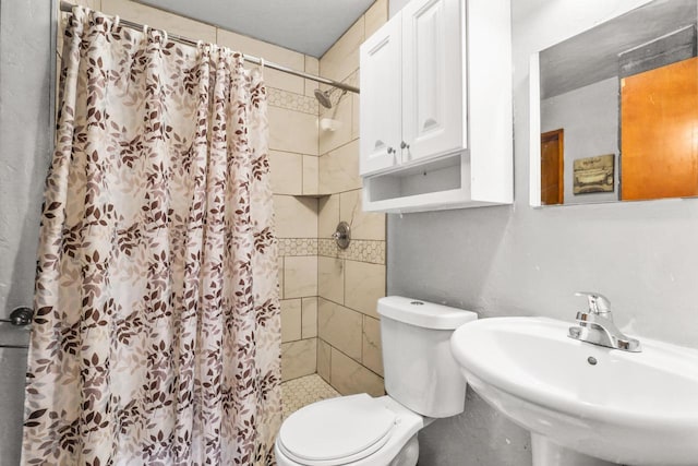 bathroom featuring curtained shower, toilet, and sink