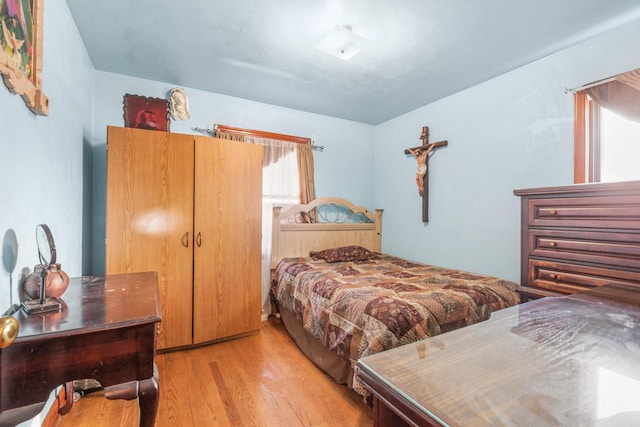 bedroom with light wood-type flooring and a closet