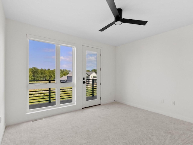 empty room featuring ceiling fan and light colored carpet