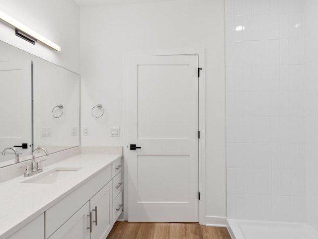 bathroom featuring hardwood / wood-style floors, walk in shower, and vanity