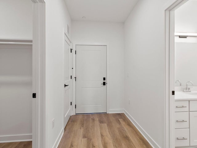 hall with sink and light hardwood / wood-style floors