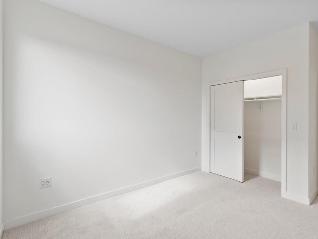 unfurnished bedroom featuring a closet and light carpet