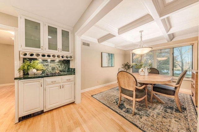 dining room featuring beamed ceiling, coffered ceiling, sink, ornamental molding, and light hardwood / wood-style flooring