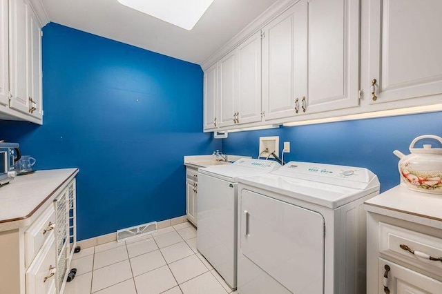 laundry room with light tile patterned floors, sink, cabinets, and washer and clothes dryer