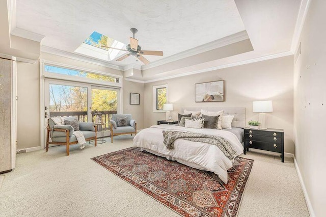 bedroom with ceiling fan, a skylight, a raised ceiling, and carpet floors