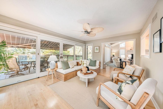 living room with light hardwood / wood-style flooring and ceiling fan