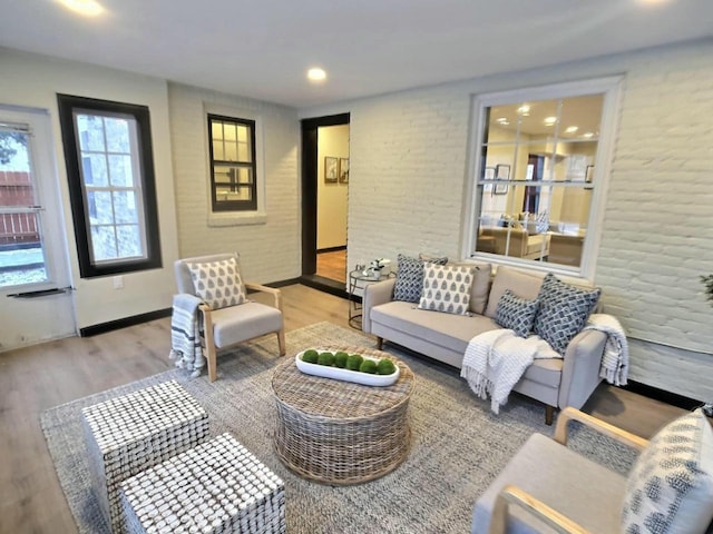 living room featuring light wood-type flooring and brick wall