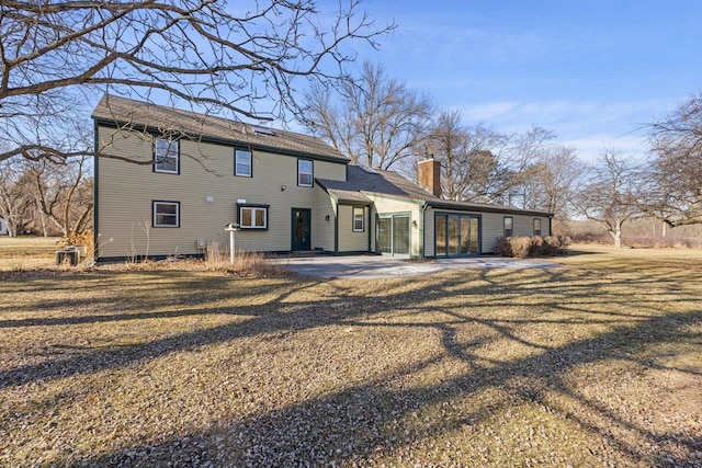 back of property with a patio area and a lawn