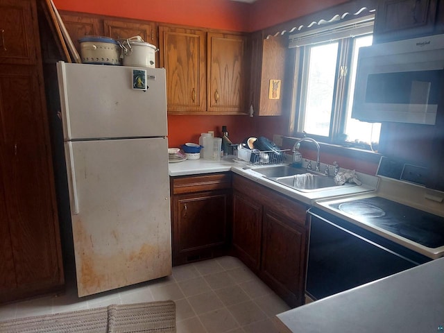 kitchen featuring sink, white appliances, and light tile patterned floors