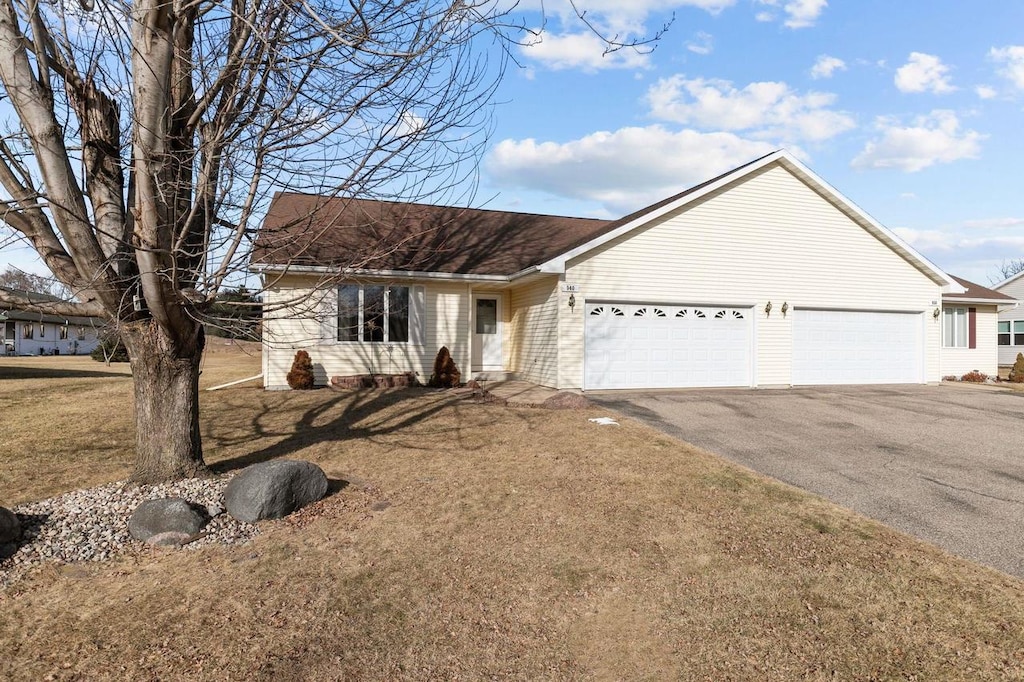 ranch-style house featuring a garage and a front yard