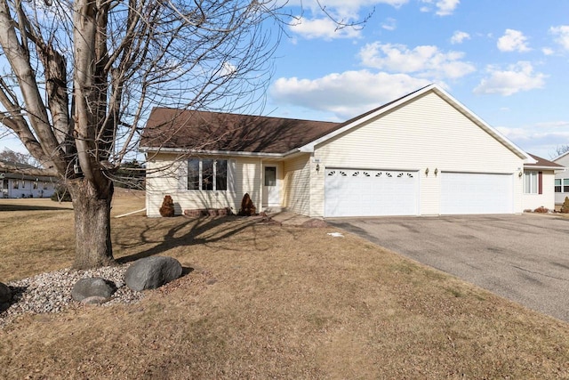 ranch-style house featuring a garage and a front yard