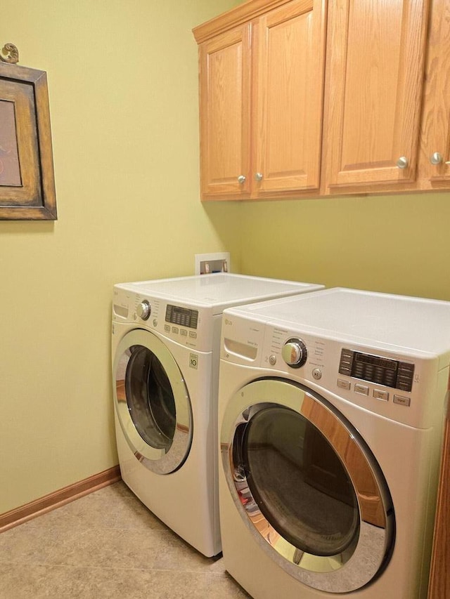 laundry room with washing machine and dryer and cabinets