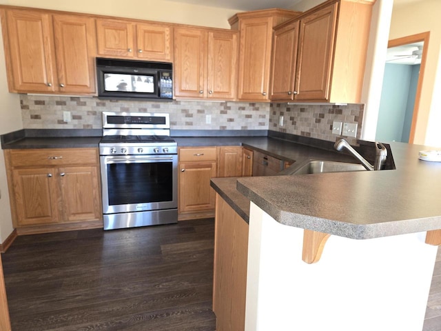 kitchen with decorative backsplash, a breakfast bar, kitchen peninsula, and stainless steel gas range oven