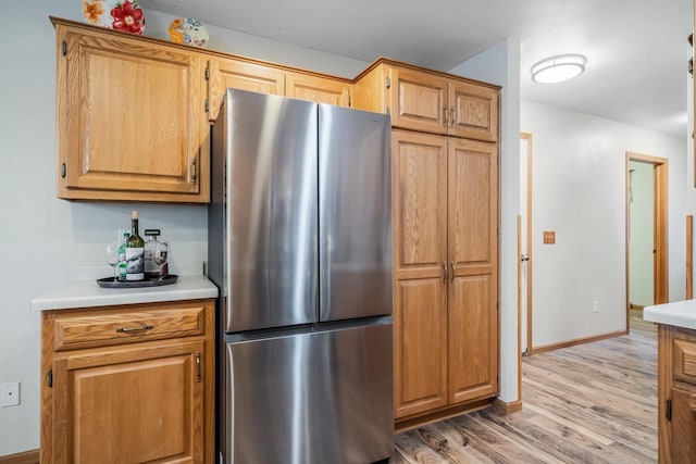 kitchen with stainless steel fridge and light wood-type flooring