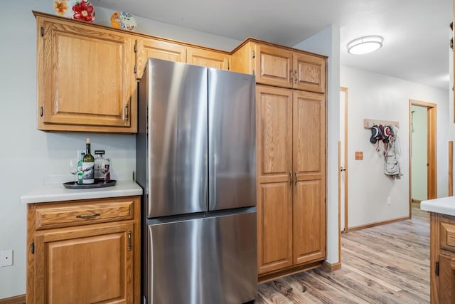 kitchen with light wood-type flooring and stainless steel fridge