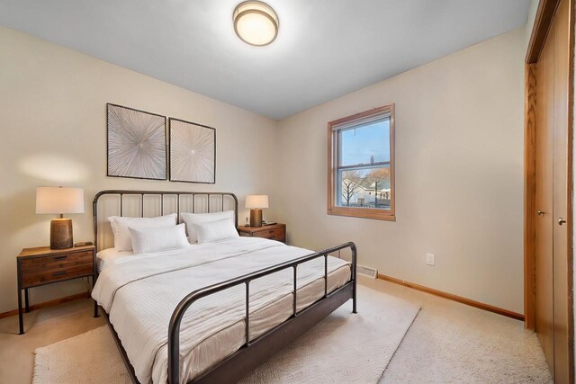 bedroom featuring light colored carpet and a closet