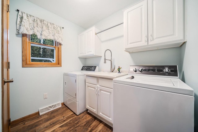 laundry area featuring cabinets, dark hardwood / wood-style floors, sink, and washing machine and clothes dryer