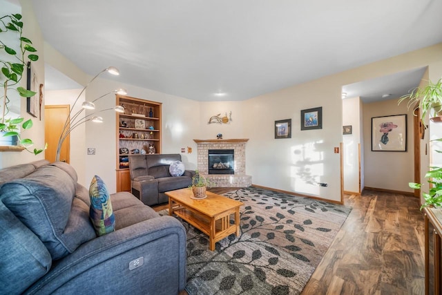 living room with a brick fireplace and wood-type flooring