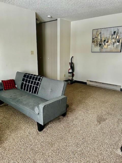 living room featuring a textured ceiling and a baseboard heating unit