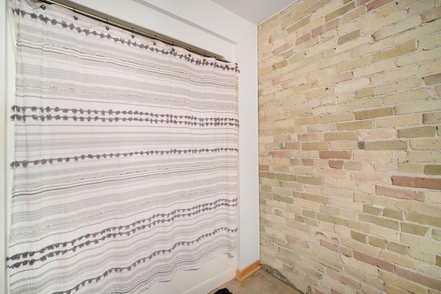 bathroom with brick wall