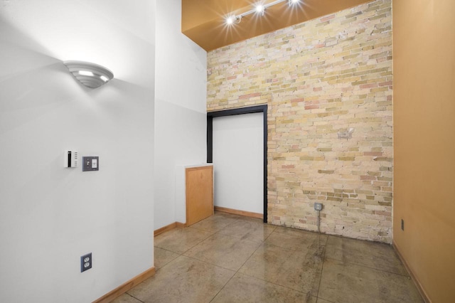 unfurnished room with brick wall