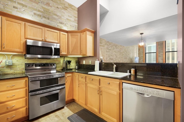 kitchen with tasteful backsplash, light tile patterned floors, sink, pendant lighting, and stainless steel appliances