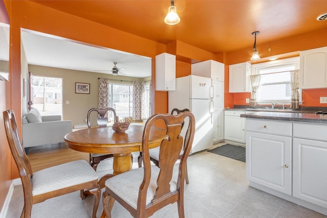 dining space featuring a healthy amount of sunlight, sink, and ceiling fan