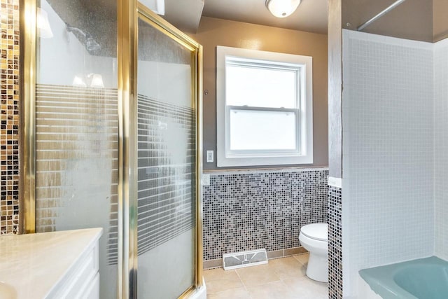 full bathroom featuring independent shower and bath, tile walls, tile patterned flooring, vanity, and toilet