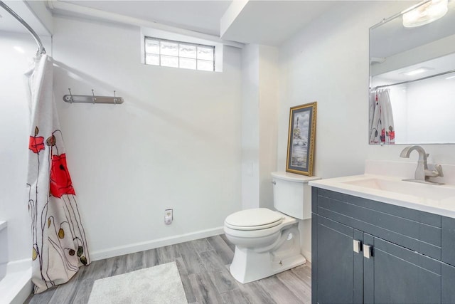 bathroom featuring wood-type flooring, toilet, and vanity