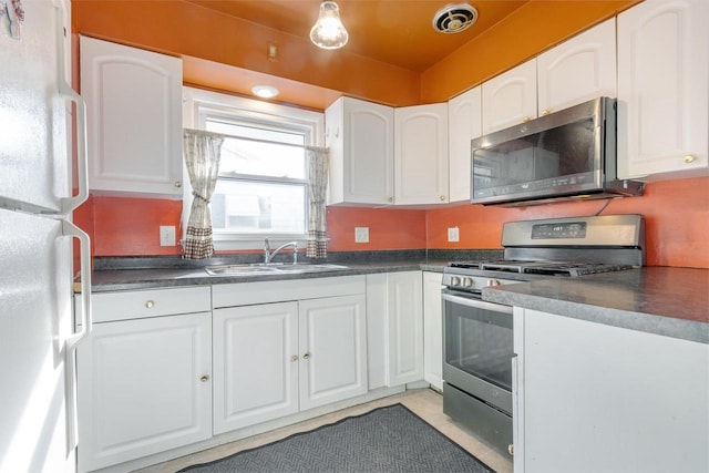 kitchen with stainless steel appliances, sink, and white cabinets