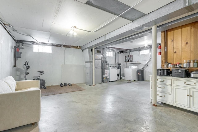 basement featuring heating unit, washing machine and dryer, and water heater