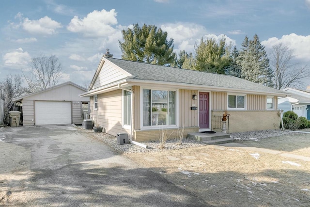 ranch-style home with a garage, an outdoor structure, and central AC unit