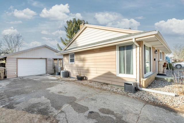 view of home's exterior featuring an outbuilding, a garage, and central air condition unit