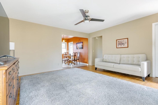 living room featuring ceiling fan and light hardwood / wood-style floors