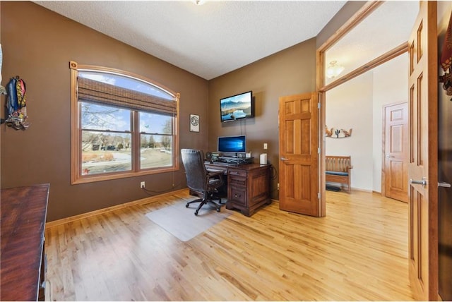 home office featuring a textured ceiling and light hardwood / wood-style flooring