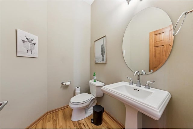 bathroom featuring wood-type flooring, sink, and toilet