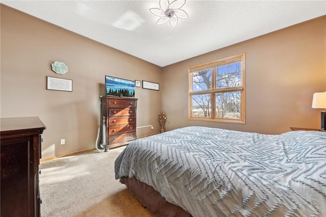 bedroom with light colored carpet and a textured ceiling