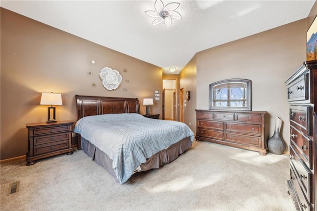 bedroom featuring light carpet and a textured ceiling