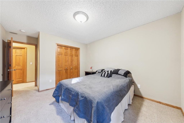 bedroom featuring light carpet, a closet, and a textured ceiling