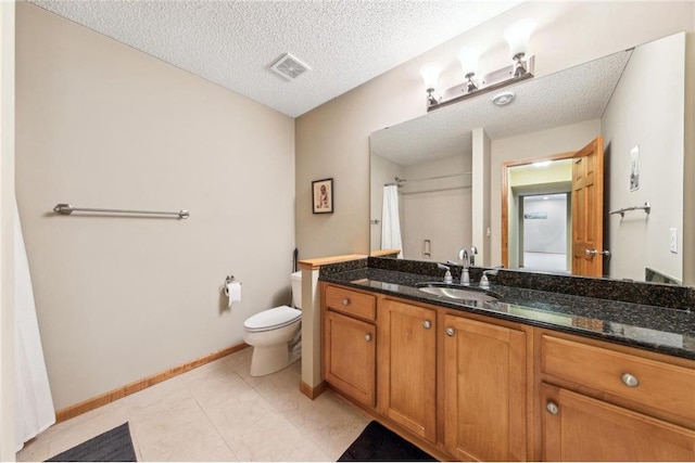 bathroom featuring vanity, tile patterned floors, toilet, and a textured ceiling