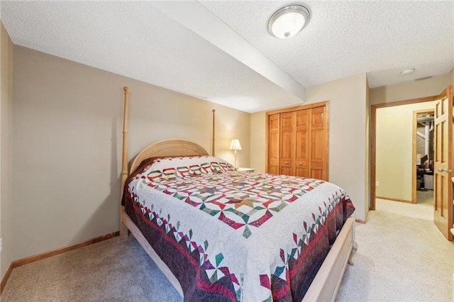 bedroom with light carpet, a textured ceiling, and a closet