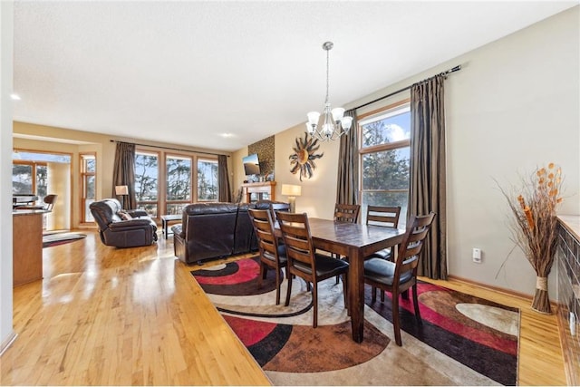 dining room with light hardwood / wood-style flooring and a chandelier