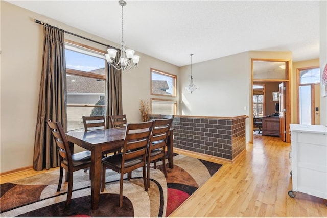 dining room with a wealth of natural light, hardwood / wood-style floors, and a chandelier