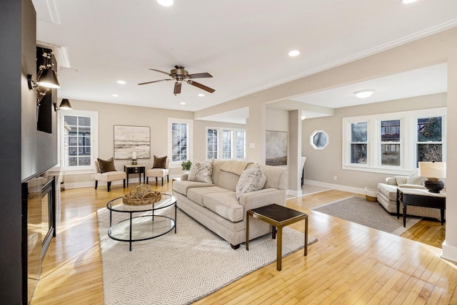 living room featuring light hardwood / wood-style flooring, a large fireplace, and a healthy amount of sunlight