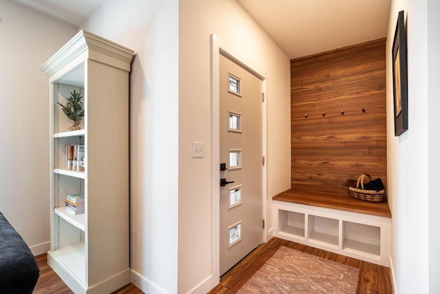 mudroom featuring hardwood / wood-style flooring and wooden walls